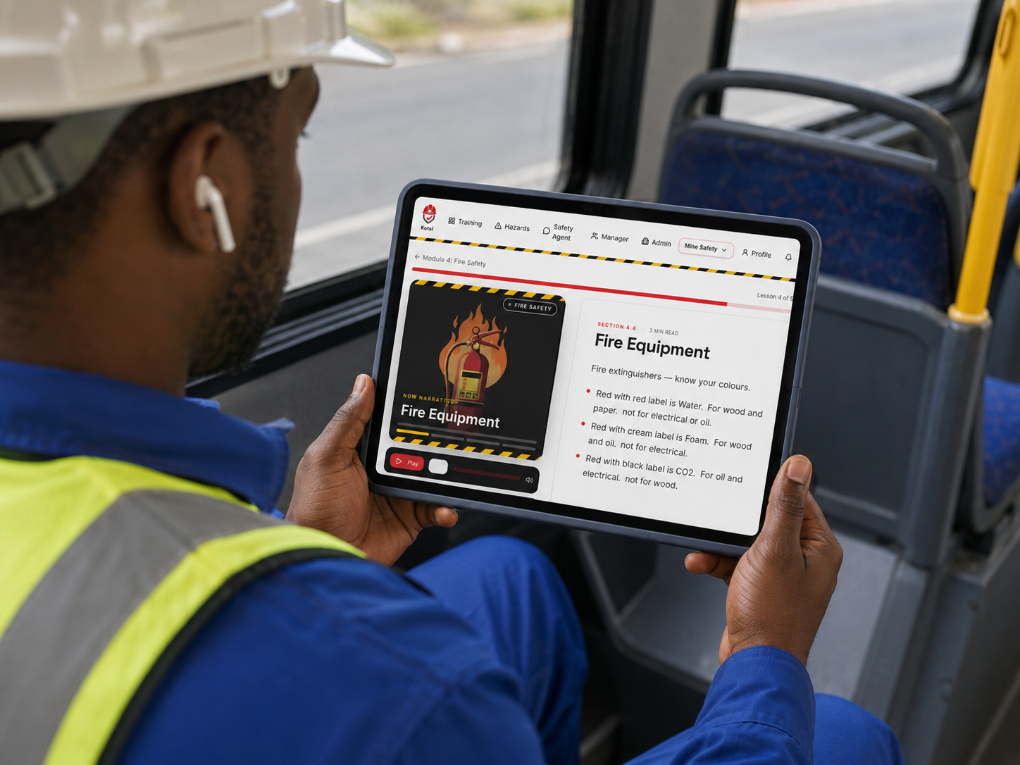 South African mine worker in hard hat and high-vis vest completing Toolbox Talk safety training on a tablet during his commute